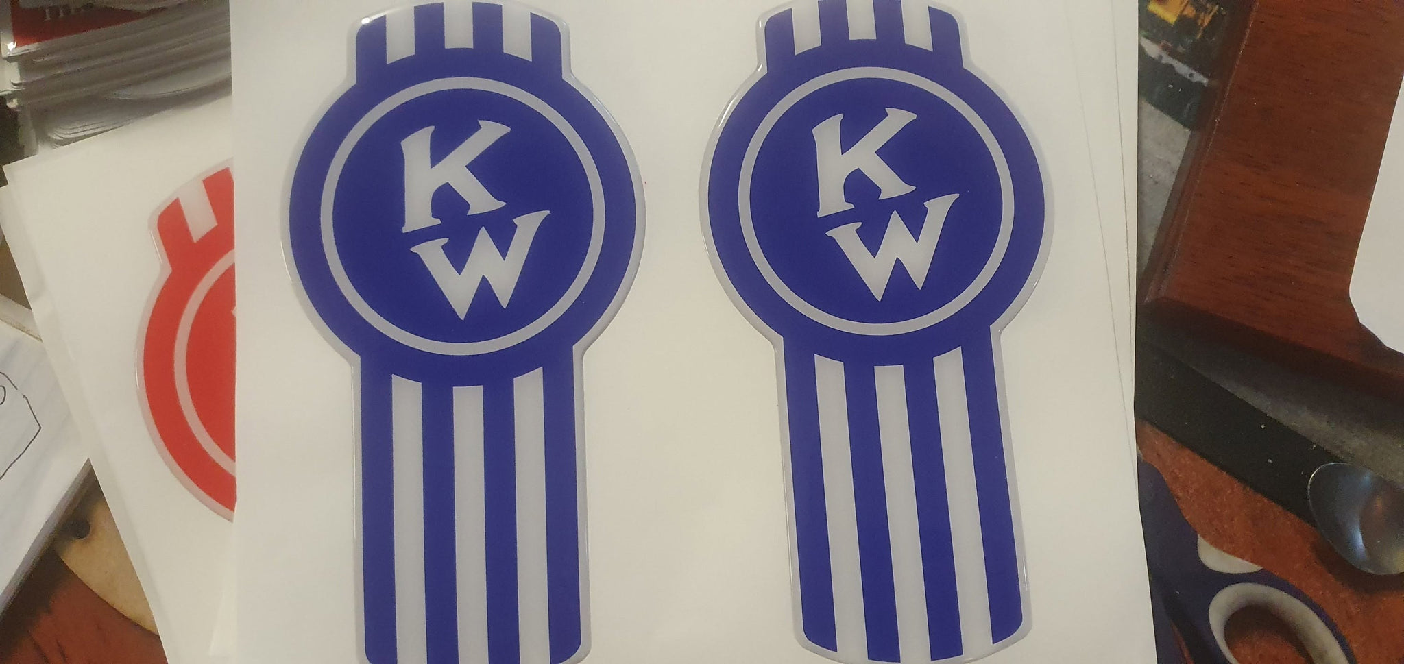Epoxy domed Kenworth 'Crooked' bug logo vinyl skin in blue.